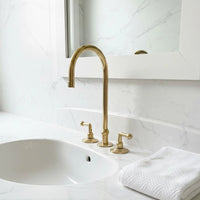 Bathroom sink with gold faucet and white towel