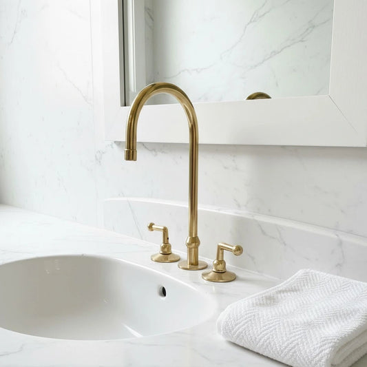 Bathroom sink with gold faucet and white towel