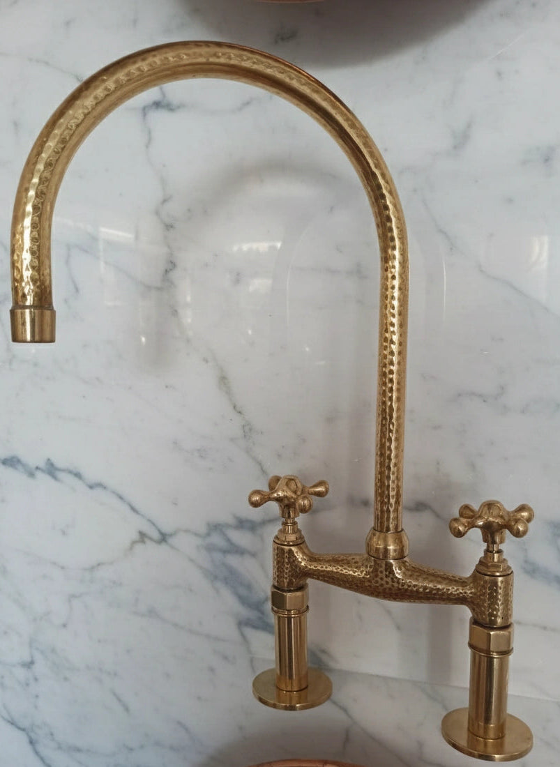 Gold faucet on a marble wall